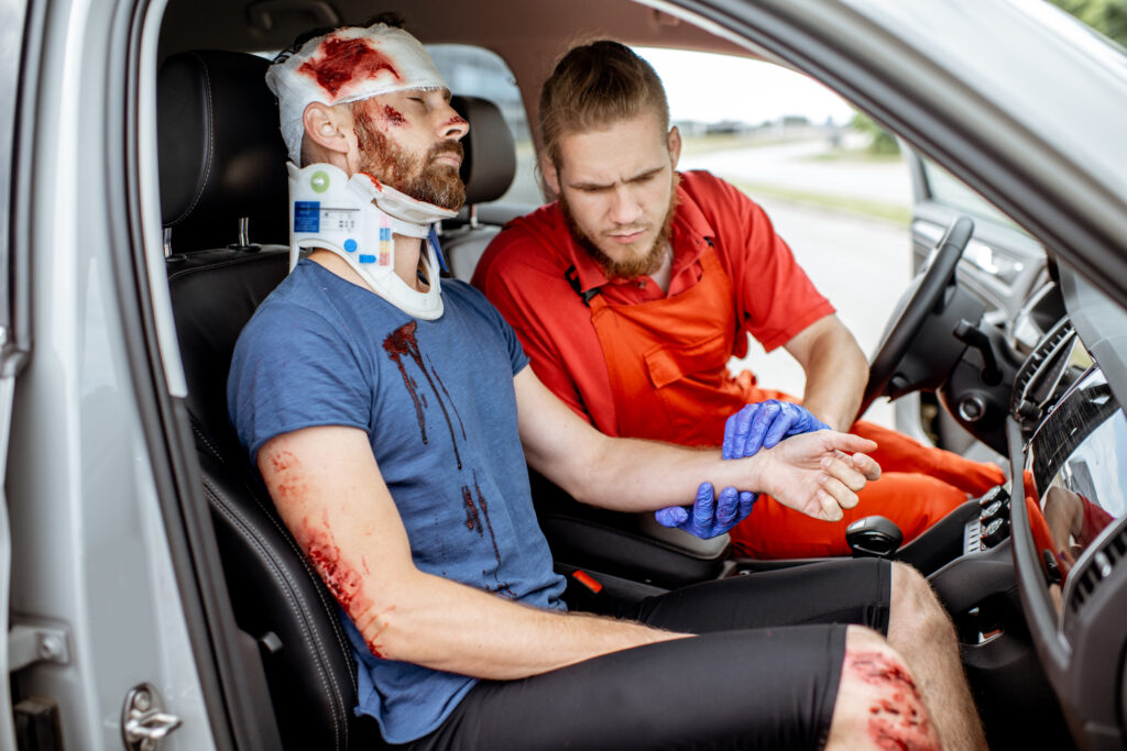 Medic providing emergency medical assistance after the road accident