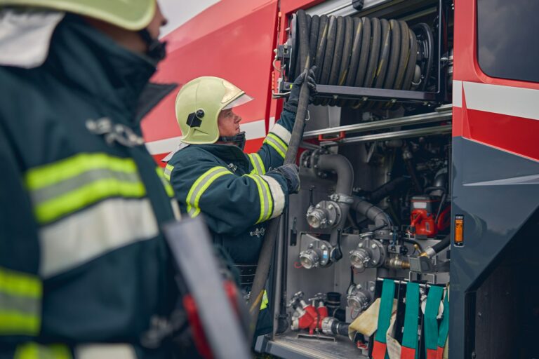 Fireman wearing safe helmet standing next to the fire engine